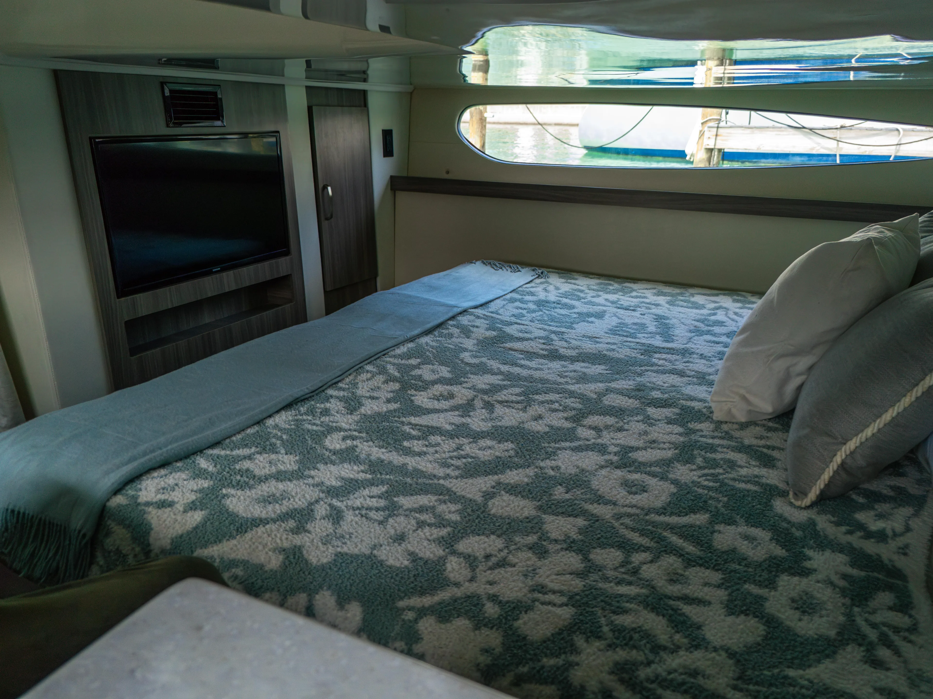 Yacht Photos Pics Luxurious cabin interior of 2023 Regal 38 FXO yacht with floral bedding and window view.