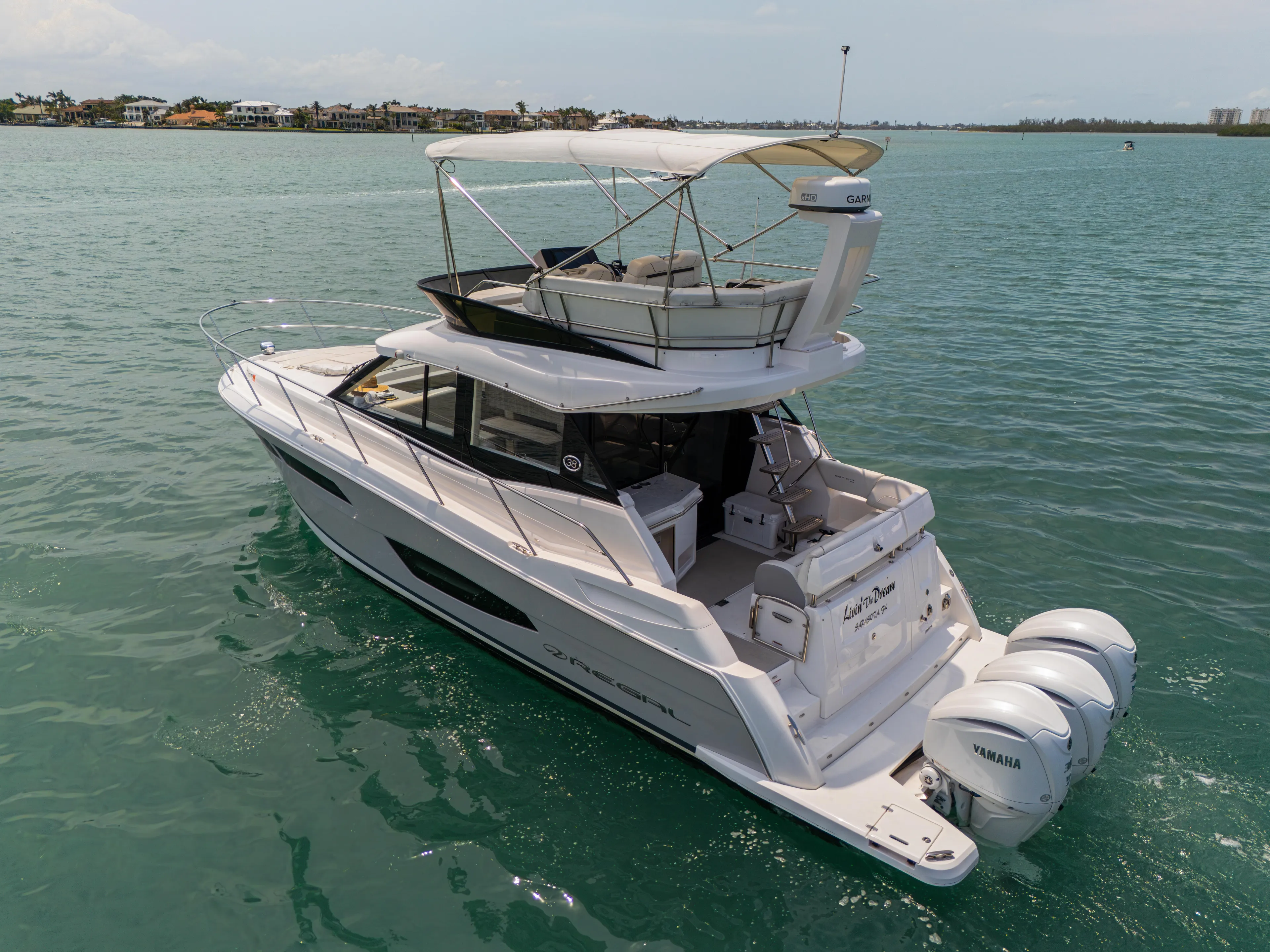  Yacht Photos Pics 2023 Regal 38 FXO yacht cruising on clear blue water.