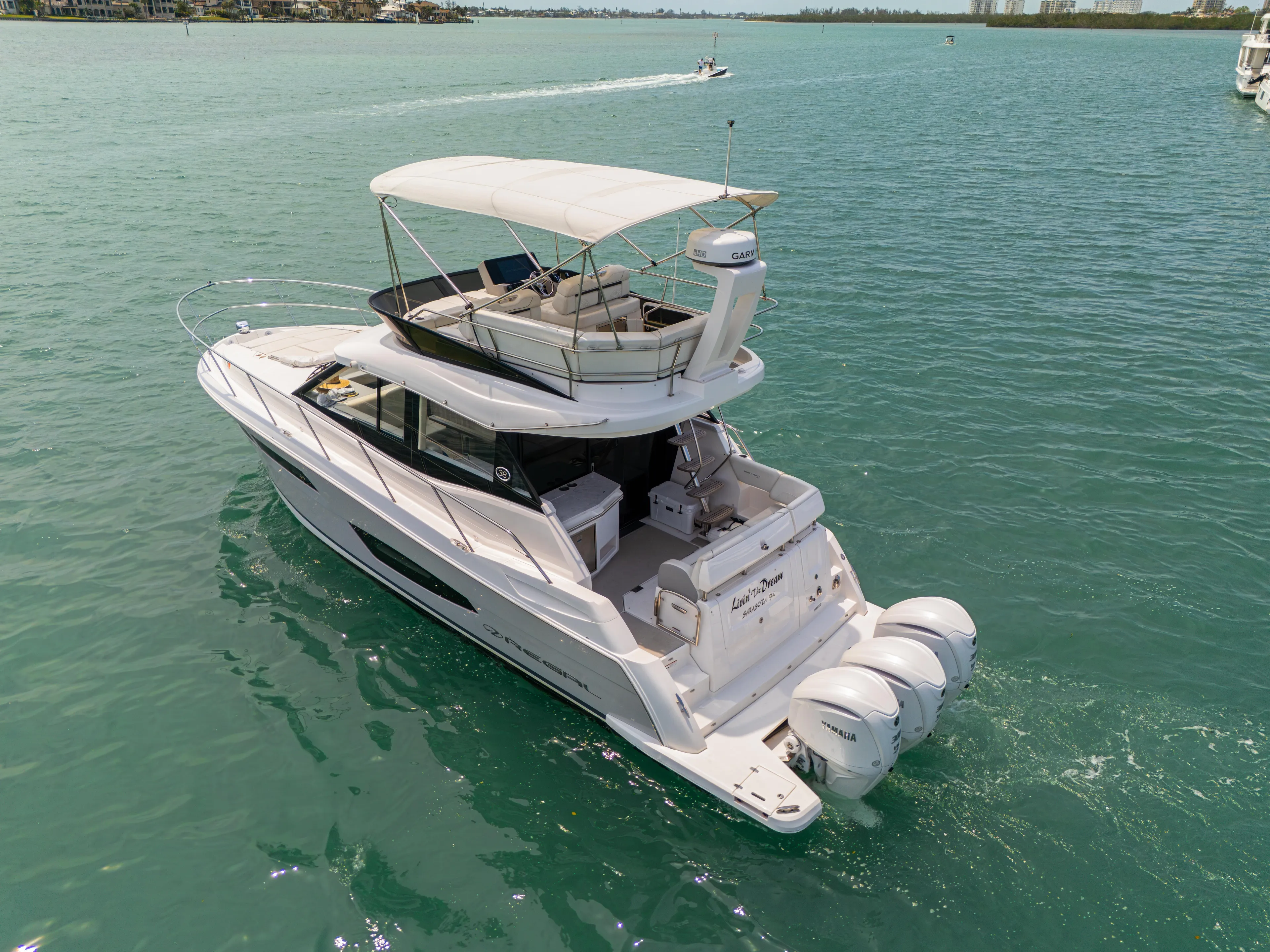  Yacht Photos Pics 2023 Regal 38 FXO yacht cruising on clear blue waters.