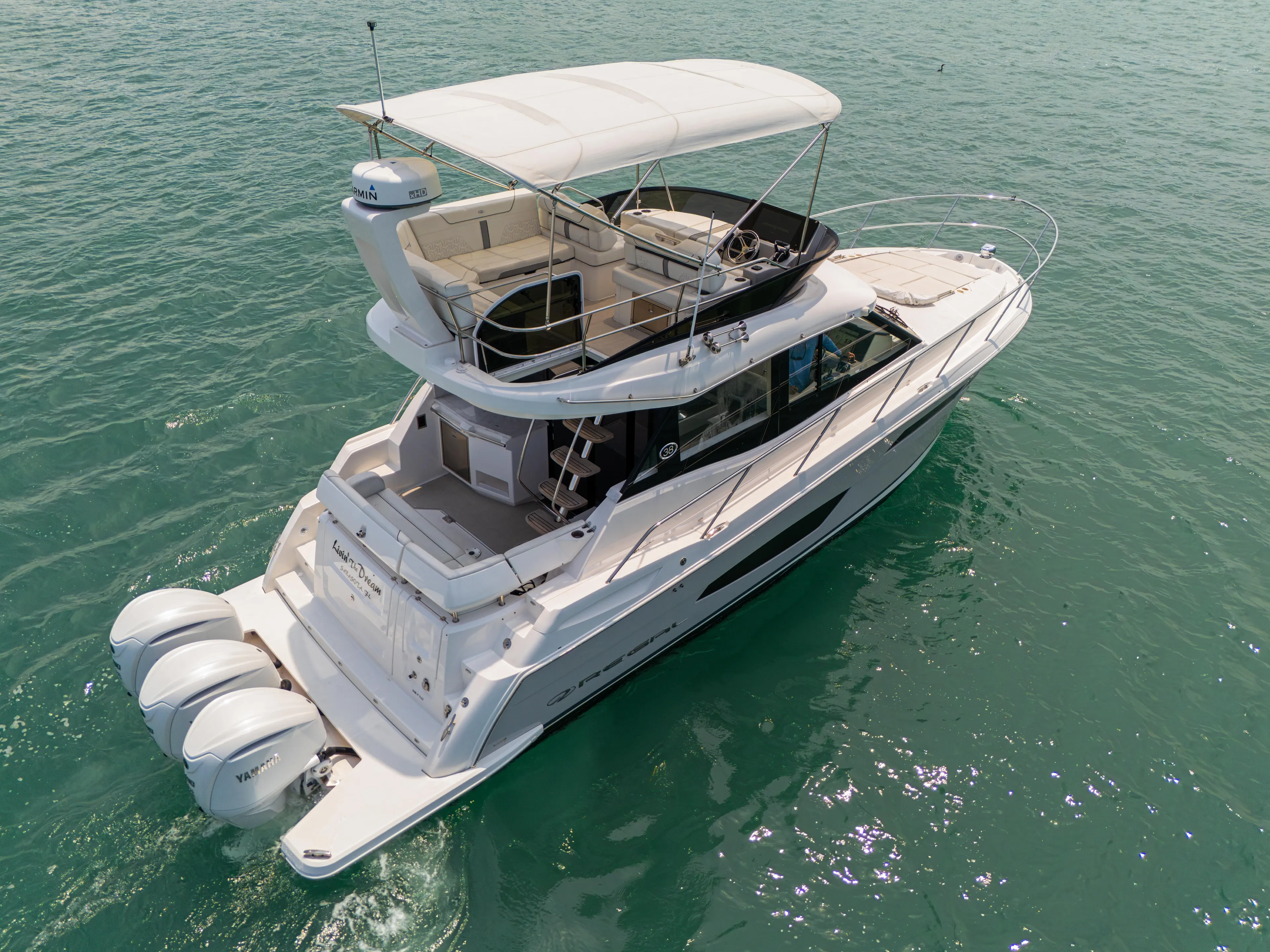  Yacht Photos Pics 2023 Regal 38 FXO yacht cruising on clear blue water.