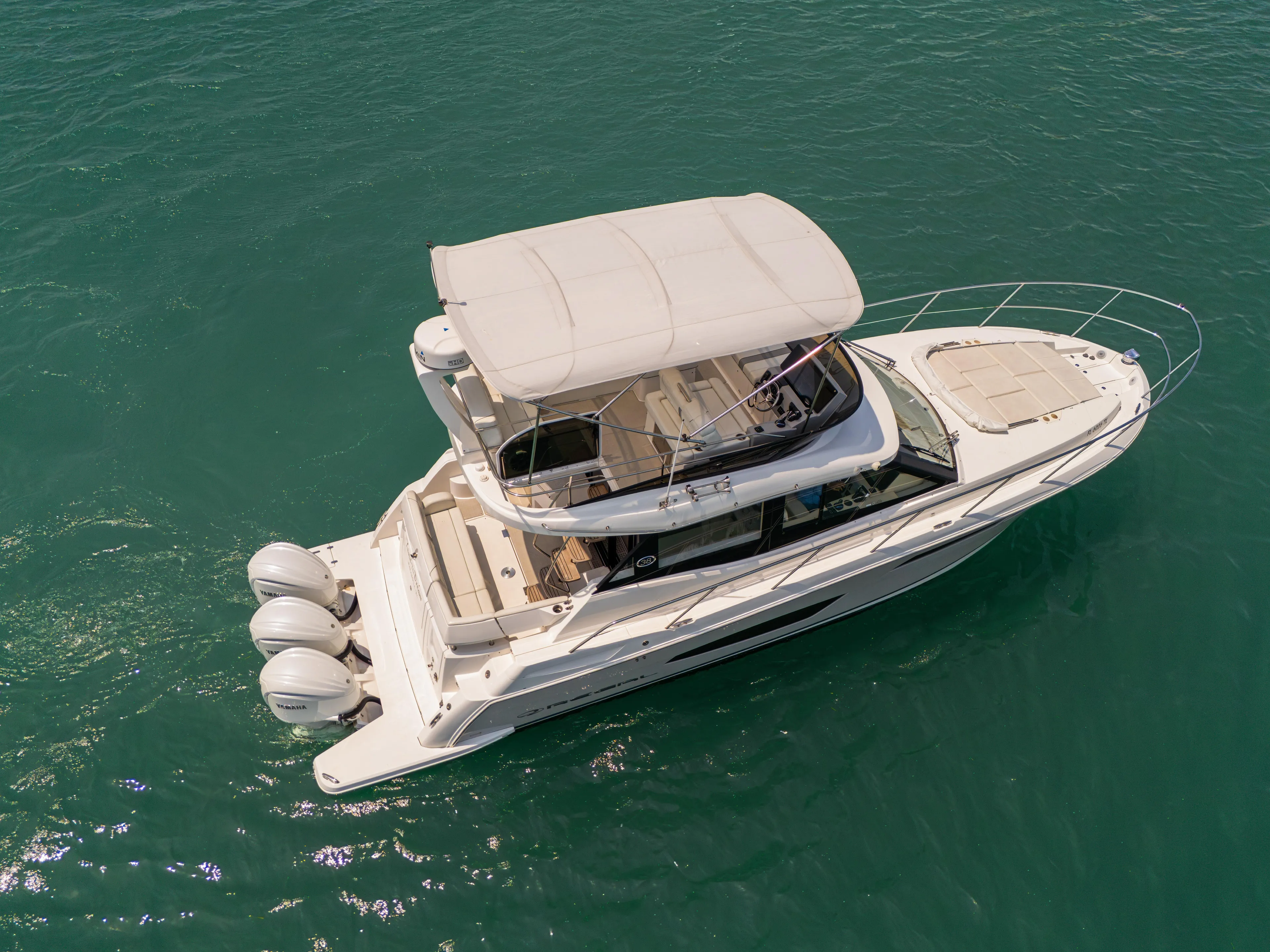  Yacht Photos Pics 2023 Regal 38 FXO luxury yacht cruising on clear blue water.