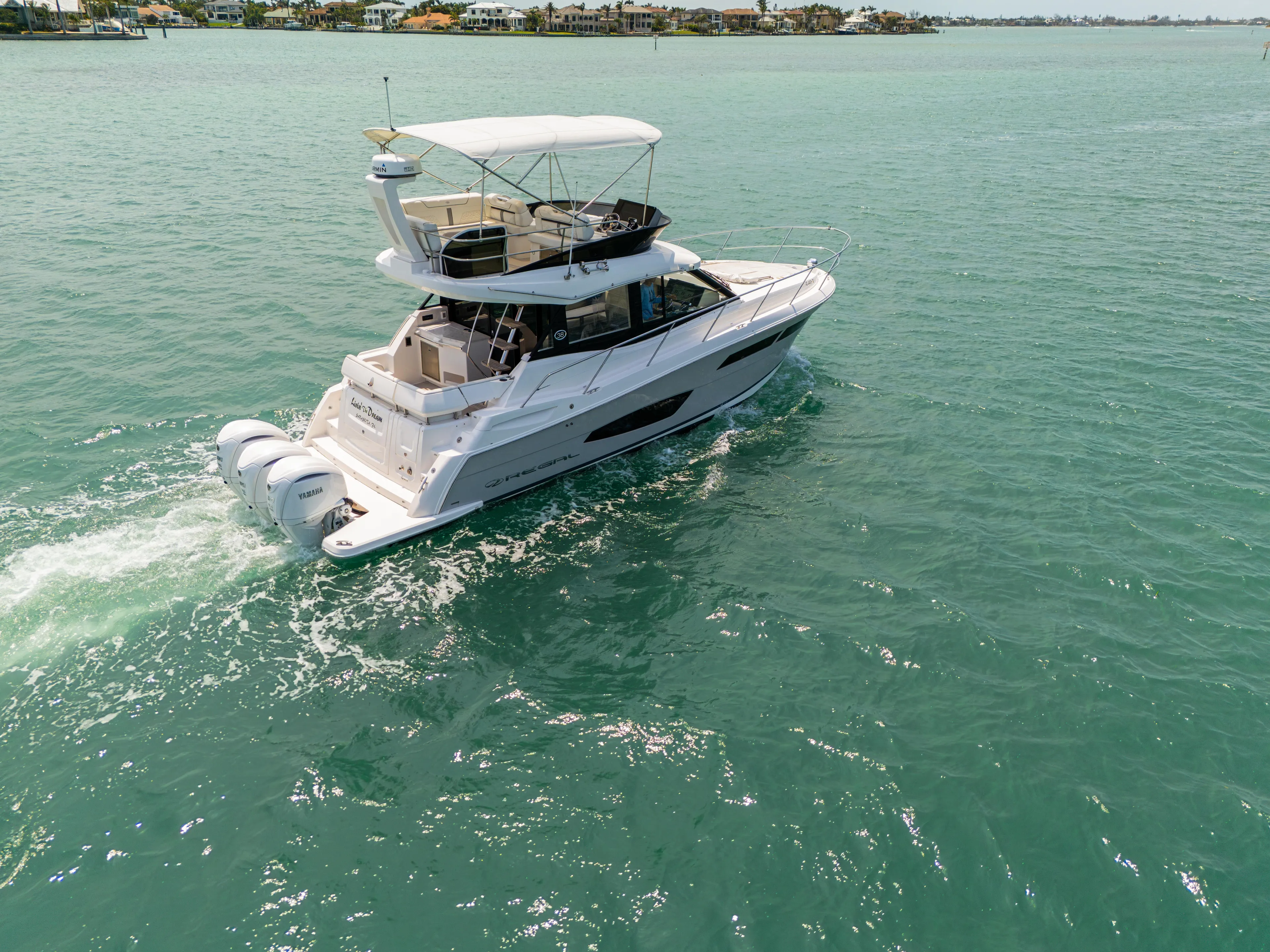  Yacht Photos Pics 2023 Regal 38 FXO yacht cruising on turquoise waters.