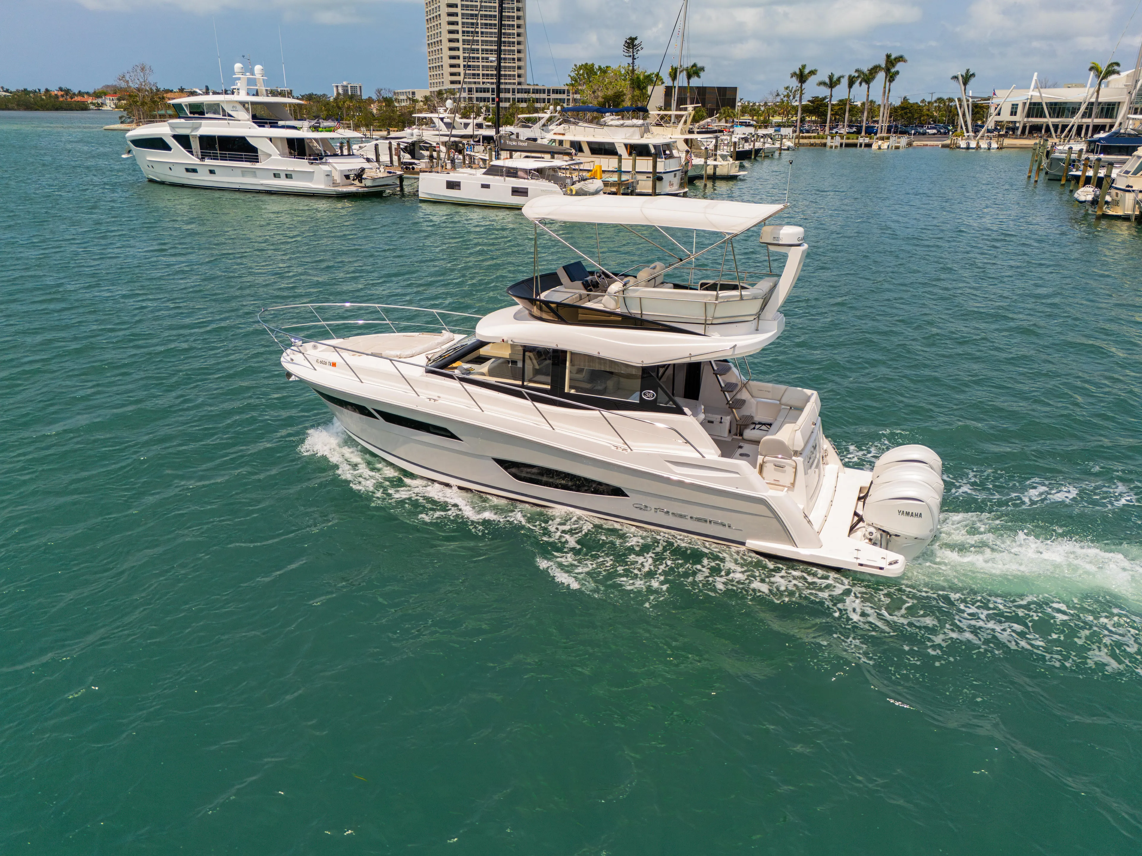  Yacht Photos Pics 2023 Regal 38 FXO yacht cruising in a marina with clear blue water.