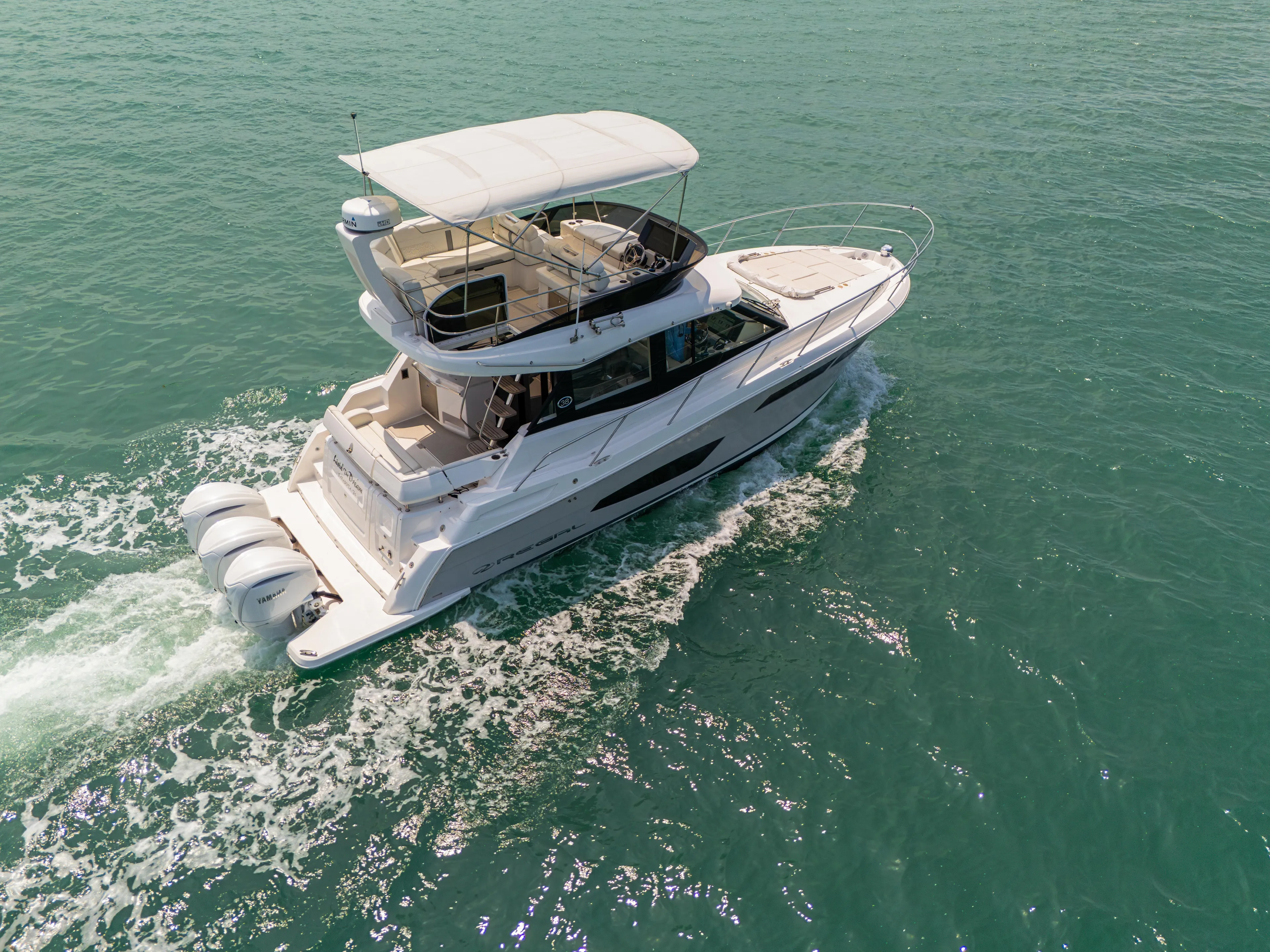  Yacht Photos Pics 2023 Regal 38 FXO yacht cruising on clear blue water.