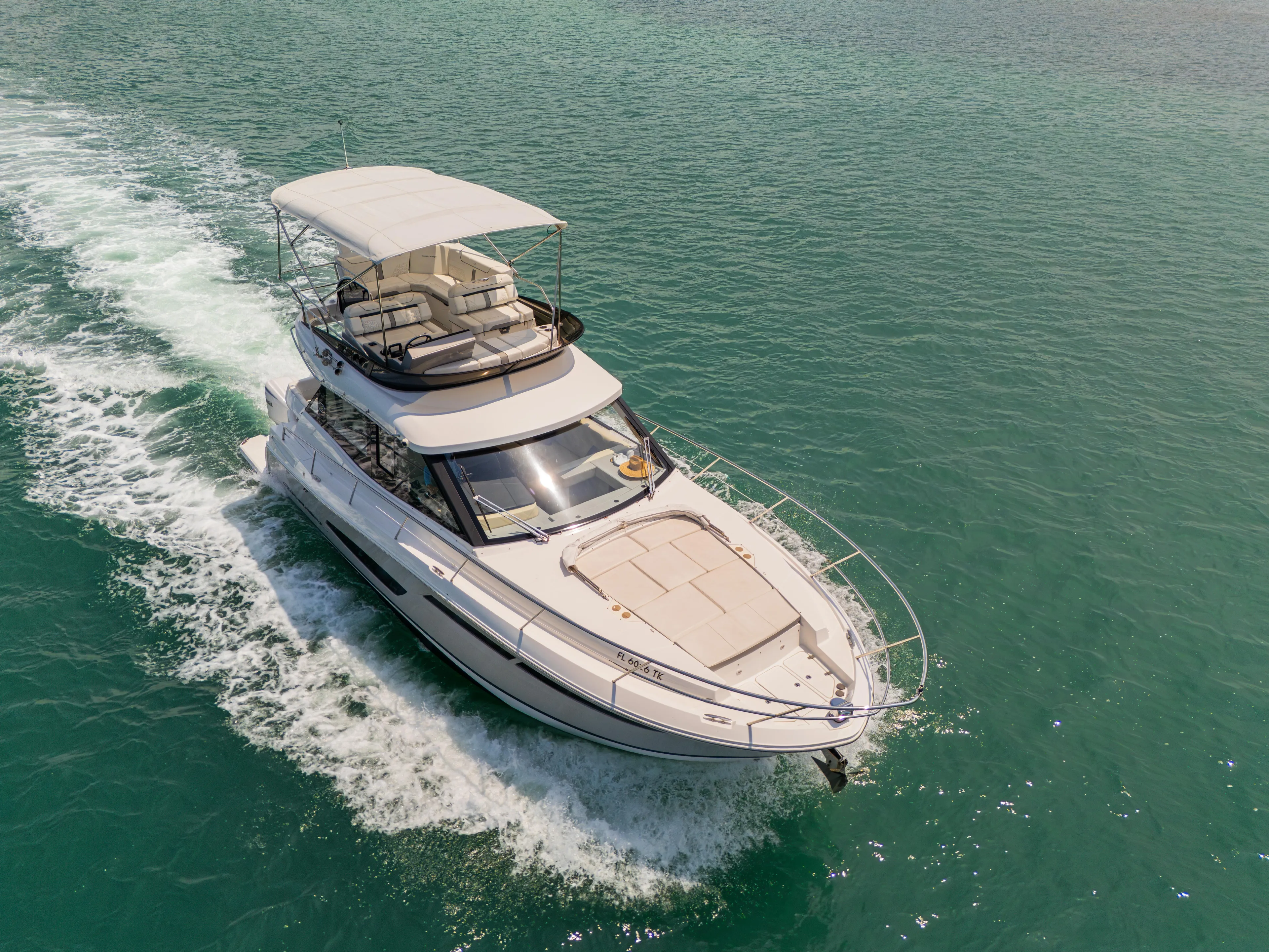  Yacht Photos Pics 2023 Regal 38 FXO yacht cruising on clear turquoise waters.