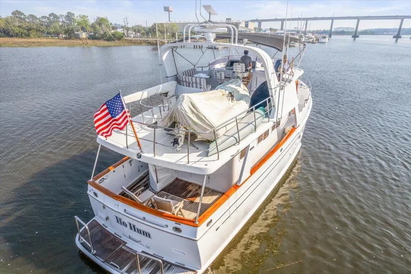  Yacht Photos Pics Selene 53 yacht from 2003 on water, American flag, bridge in background.