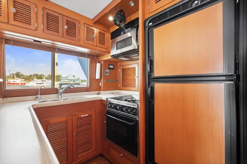  Yacht Photos Pics Compact kitchen in a 2003 Selene 53 yacht with wooden cabinetry and modern appliances.