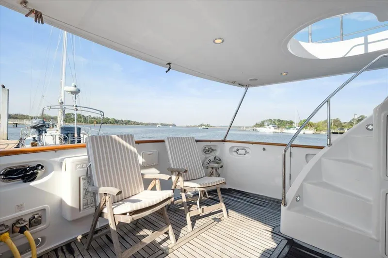  Yacht Photos Pics Luxurious 2003 Selene 53 yacht deck with chairs, overlooking serene marina view.