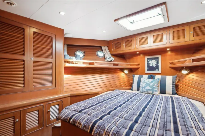  Yacht Photos Pics Luxurious cabin interior of 2003 Selene 53 yacht with striped bedding and wooden finishes.