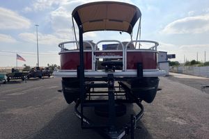 2025 Sun Tracker Bass Buggy 18 DLX pontoon boat on trailer, outdoor display.