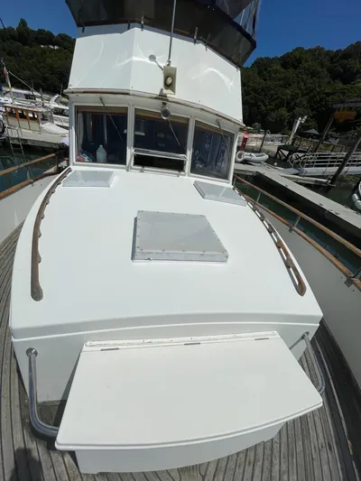  Yacht Photos Pics 1987 Grand Banks 42 Motoryacht deck view at marina, featuring white exterior and wooden railings.