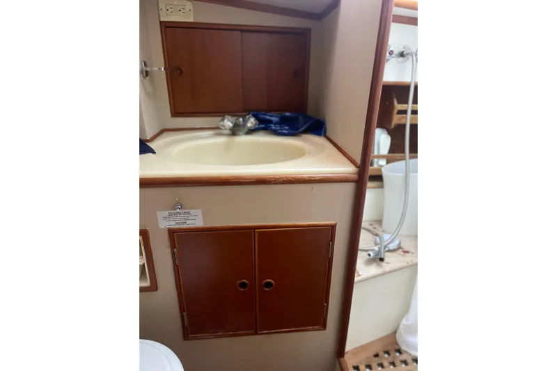  Yacht Photos Pics 1987 Grand Banks 42 Motoryacht bathroom with sink, wooden cabinets, and shower area.