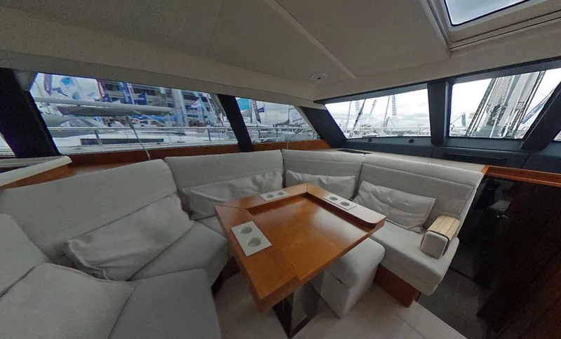  Yacht Photos Pics Interior of 2016 Moody 54 DS yacht with plush seating and wooden table.