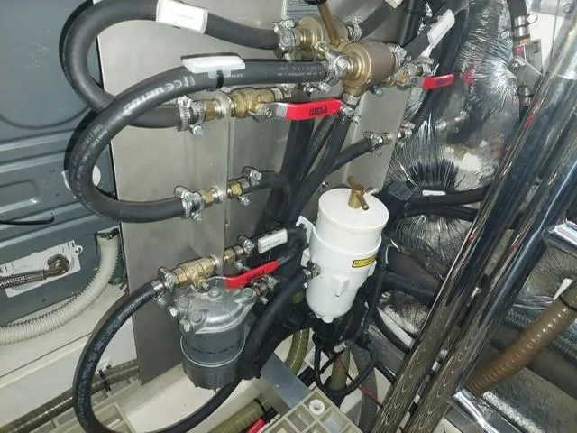  Yacht Photos Pics Engine room of a 2016 Moody 54 DS yacht, showcasing complex piping and machinery.