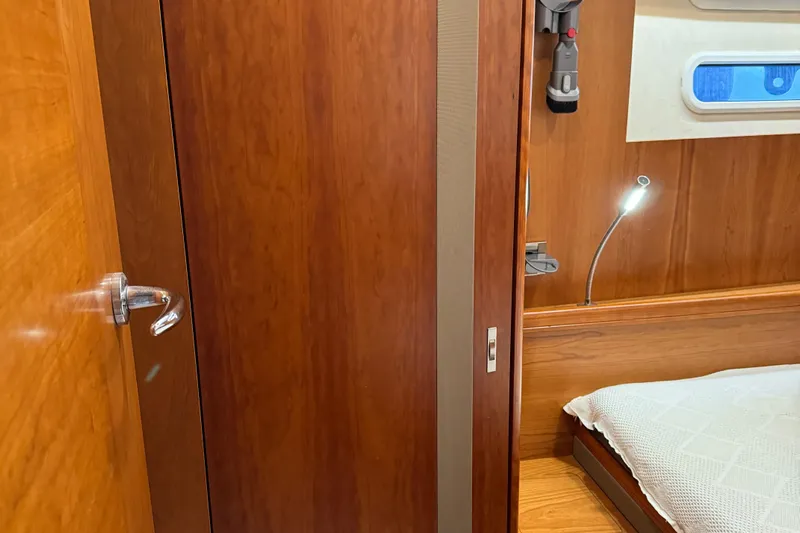  Yacht Photos Pics Interior of 2016 Moody 54 DS yacht with wooden paneling and cozy bed.