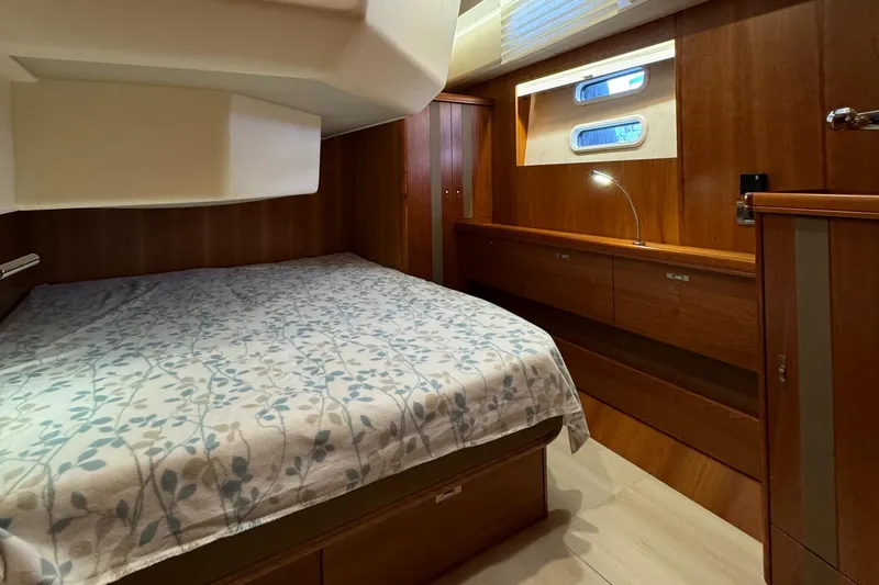  Yacht Photos Pics Luxurious cabin interior of 2016 Moody 54 DS yacht with wooden furnishings and cozy bedding.