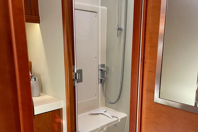  Yacht Photos Pics Bathroom interior of 2016 Moody 54 DS yacht with shower and wooden cabinetry.