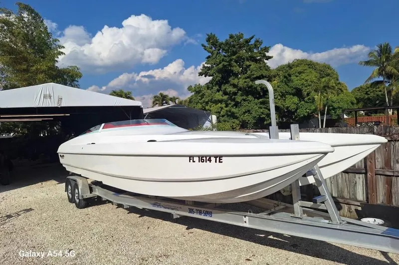  Yacht Photos Pics White 2020 HellKats 30 boat on trailer, parked outdoors under a clear blue sky.