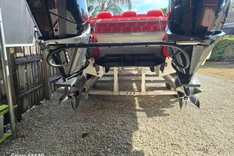  Yacht Photos Pics 2020 HellKats 30 boat with dual outboard engines and red seating, parked on gravel.