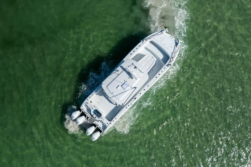  Yacht Photos Pics Aerial view of 2024 Costa Custom Boats 34 SV cruising in clear green water.