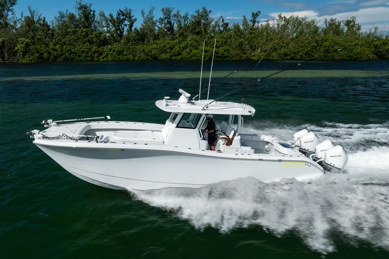  Yacht Photos Pics 2024 Costa Custom Boats 34 SV cruising on water, surrounded by lush greenery.