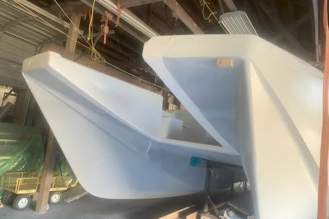  Yacht Photos Pics 2027 Compmillenia Lightspeed Tender in a workshop, showcasing sleek hull design.