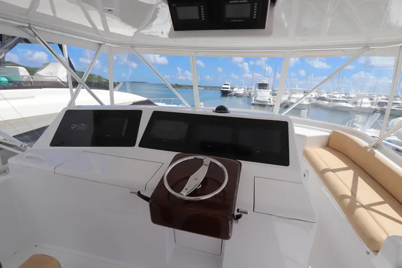 Breakaway Yacht Photos Pics Helm of 2004 Viking 56 yacht with marina view, featuring modern controls and seating.