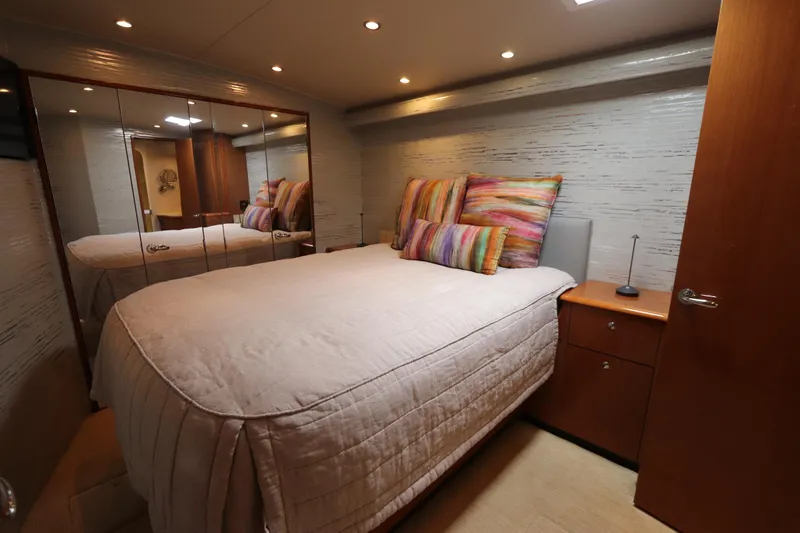 Breakaway Yacht Photos Pics Luxurious bedroom interior of a 2004 Viking 56 yacht with mirrored closet and colorful pillows.