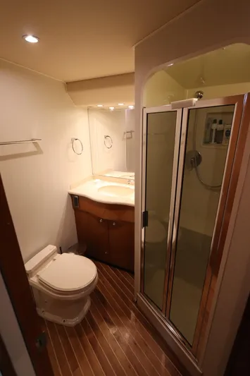 Breakaway Yacht Photos Pics 2004 Viking 56 yacht bathroom with shower, toilet, and wooden flooring.