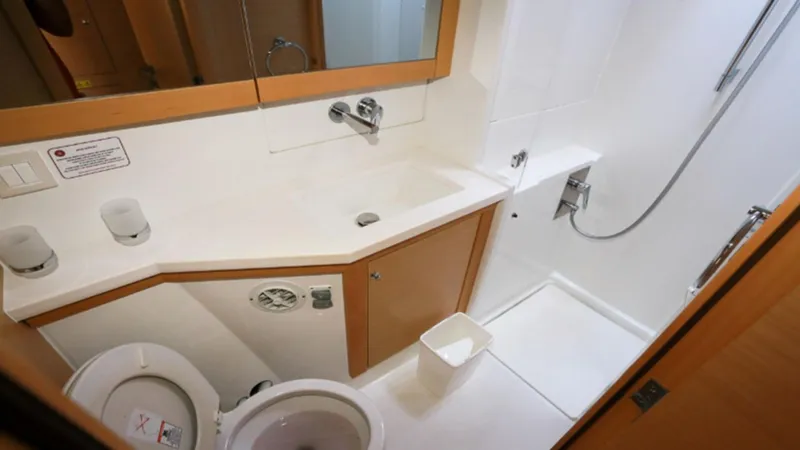  Yacht Photos Pics Modern bathroom in a 2017 Lagoon 450 F yacht, featuring a compact design with shower and toilet.
