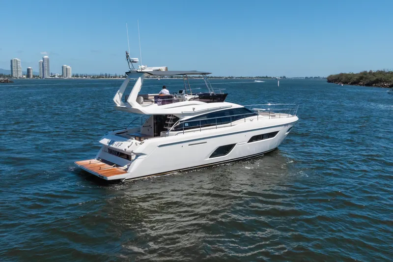 Sublime Yacht Photos Pics 2021 Ferretti Yachts 550 cruising on a sunny day near city skyline.