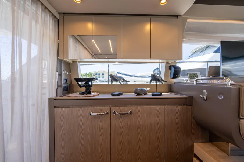 Sublime Yacht Photos Pics Interior of 2021 Ferretti Yachts 550, featuring elegant cabinetry and decorative sculptures.
