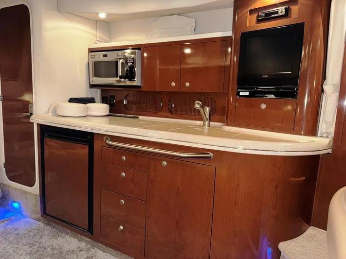  Yacht Photos Pics 2008 Sea Ray 340 Sundancer interior kitchen with wood cabinets, microwave, and mini-fridge.