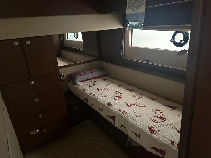  Yacht Photos Pics 2015 Sea Ray 510 Fly cabin with single bed, nautical-themed bedding, and storage drawers.