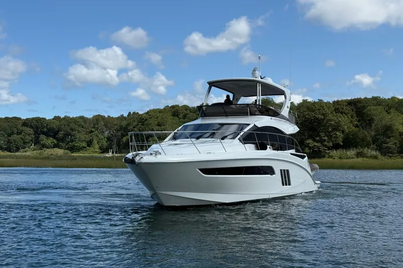  Yacht Photos Pics 2015 Sea Ray 510 Fly yacht cruising on a serene lake under a clear blue sky.