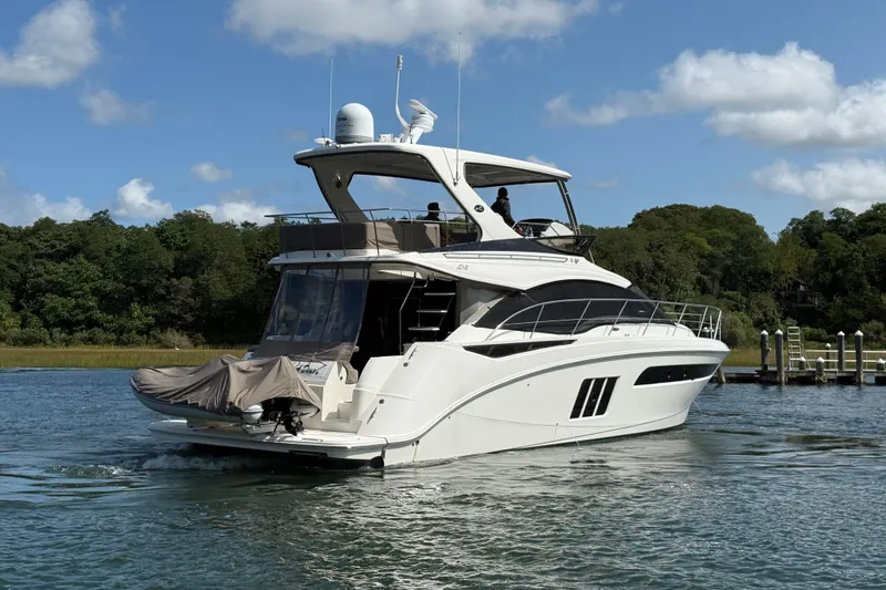  Yacht Photos Pics 2015 Sea Ray 510 Fly yacht cruising on a sunny day with lush greenery in the background.