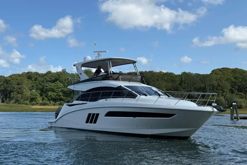  Yacht Photos Pics 2015 Sea Ray 510 Fly yacht cruising on a serene waterway under a blue sky.