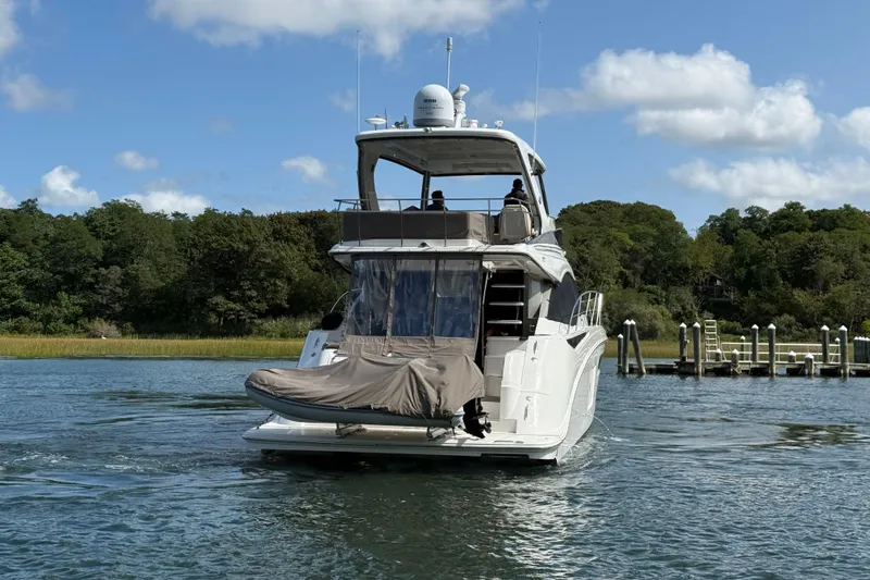  Yacht Photos Pics 2015 Sea Ray 510 Fly yacht cruising on a serene waterway with lush greenery.