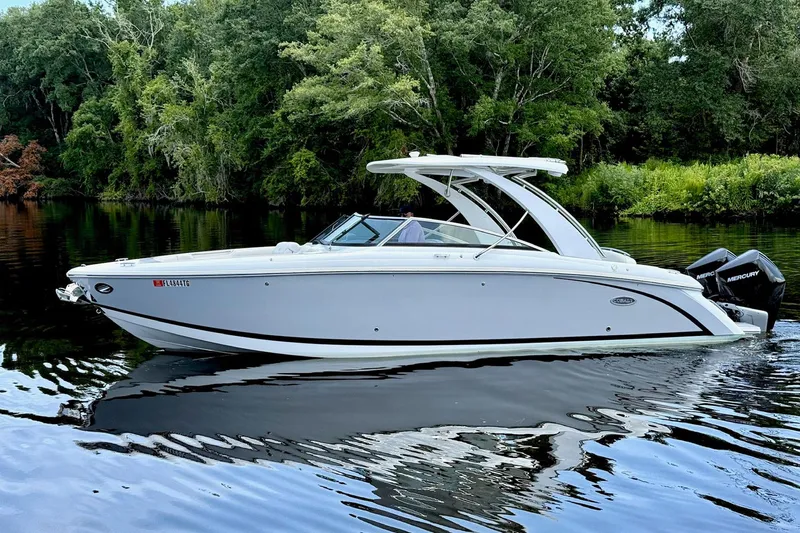 Drama Free Yacht Photos Pics 2022 Cobalt R30 boat on calm water with lush green forest background.