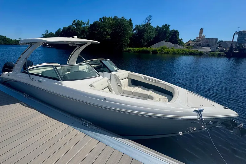 Drama Free Yacht Photos Pics 2022 Cobalt R30 boat docked on a serene lake under clear blue skies.