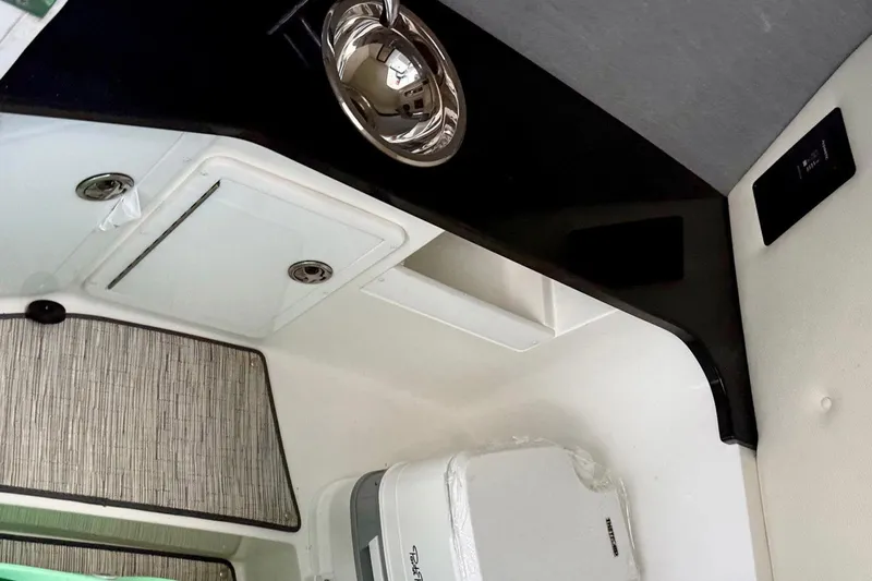Drama Free Yacht Photos Pics Interior of 2022 Cobalt R30 boat featuring a compact kitchenette with sink and storage.