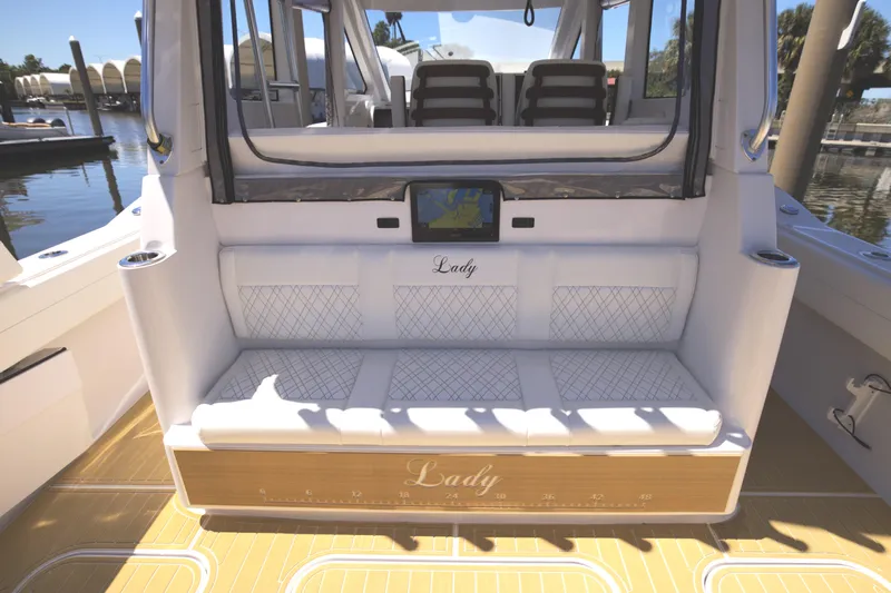 New! Hybrid Design Yacht Photos Pics Century NAV4100 CC-H (Twins) 2025 boat interior with cushioned seating and navigation display.