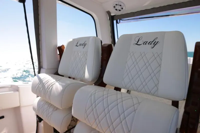 New! Hybrid Design Yacht Photos Pics Luxurious white seats on a 2025 Century NAV4100 CC-H boat, embroidered with "Lady."