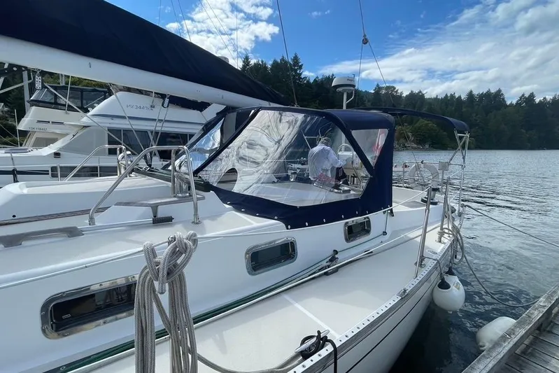 "snapdragon" Yacht Photos Pics Sailboat Tartan 4100, 1999 model, docked by a serene lake under a partly cloudy sky.