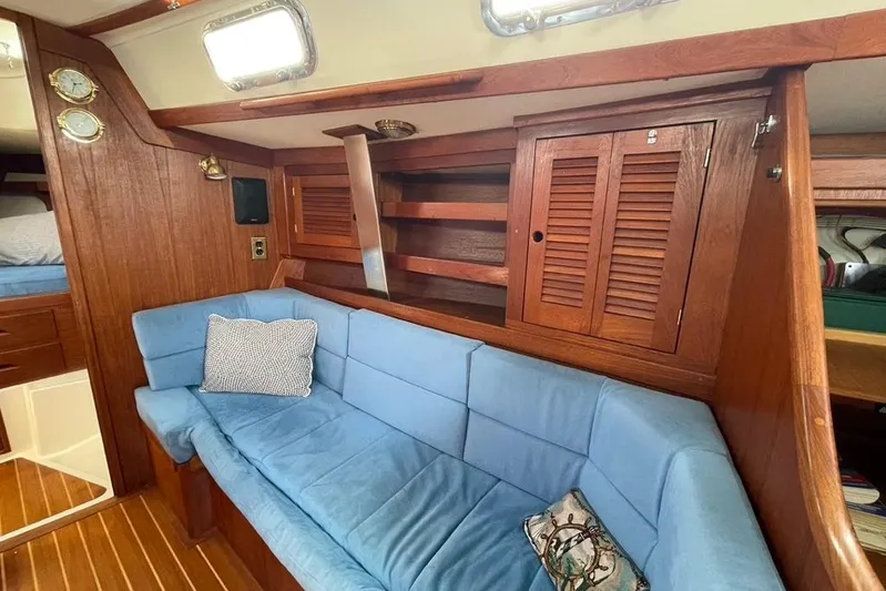 "snapdragon" Yacht Photos Pics Interior of 1999 Tartan 4100 sailboat with blue cushioned seating and wooden cabinetry.
