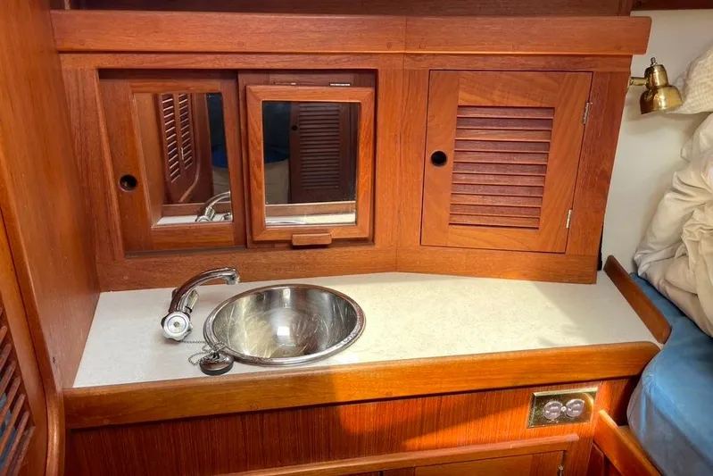 "snapdragon" Yacht Photos Pics Wooden vanity with sink and mirror in 1999 Tartan 4100 yacht cabin.