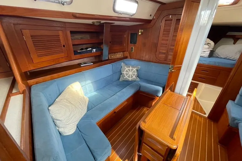 "snapdragon" Yacht Photos Pics Cozy interior of 1999 Tartan 4100 sailboat with blue seating and wooden accents.