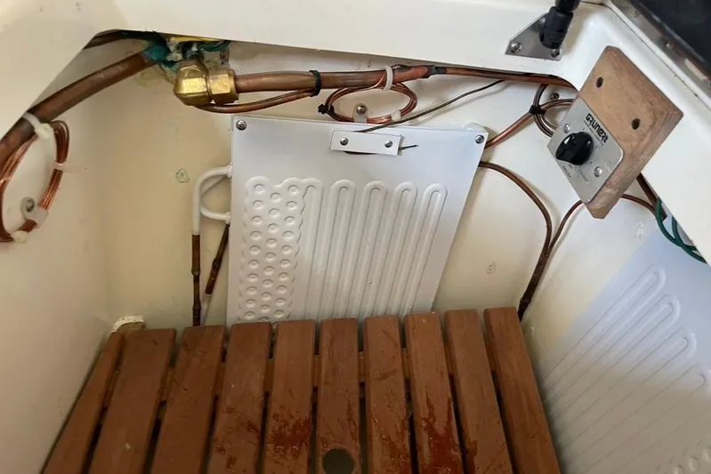 "snapdragon" Yacht Photos Pics Engine compartment of 1999 Tartan 4100 sailboat with wooden slats and copper piping.