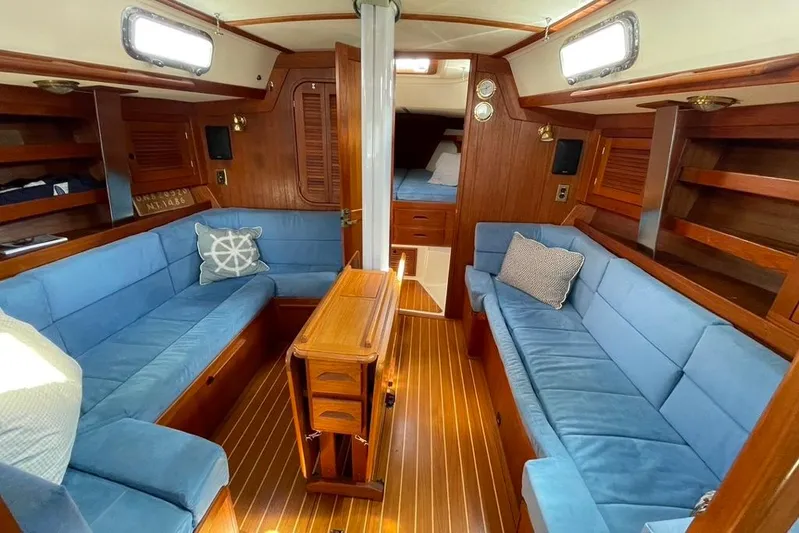 "snapdragon" Yacht Photos Pics Interior of a 1999 Tartan 4100 sailboat with blue seating and wooden finishes.