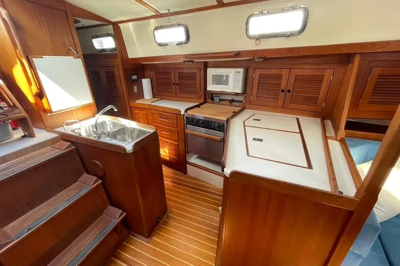 "snapdragon" Yacht Photos Pics Interior of 1999 Tartan 4100 sailboat with wooden cabinetry and modern kitchen amenities.
